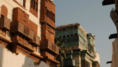 Historic Jeddah Al Balad street with restored Saudi heritage architecture, carved wooden traditional windows, and coral stone