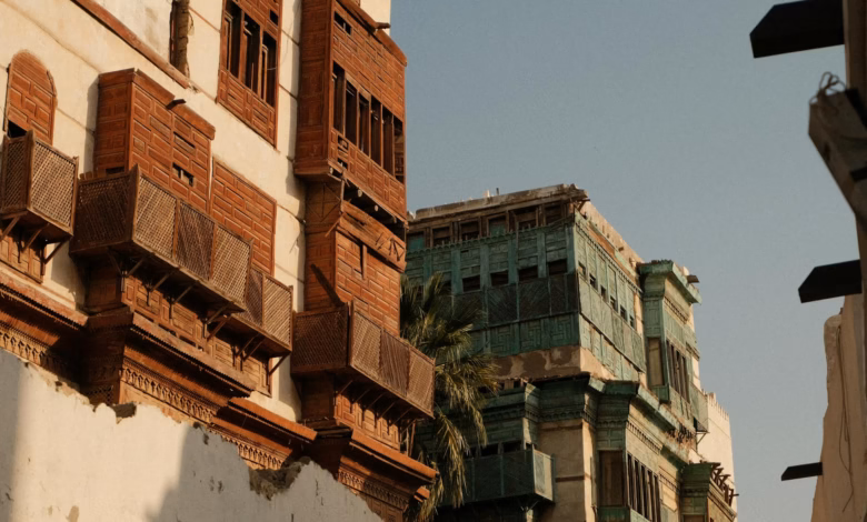 Historic Jeddah Al Balad street with restored Saudi heritage architecture, carved wooden traditional windows, and coral stone