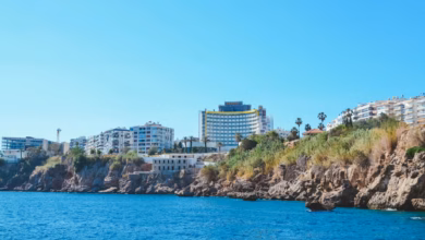 Turquoise Mediterranean coastline near Antalya with sandy beaches, resort-lined shore, and clear blue sea.