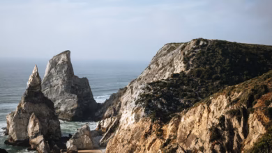 Golden sandy beach along Portugal’s Atlantic coast with dramatic scenic cliffs and rolling ocean waves, a picturesque family