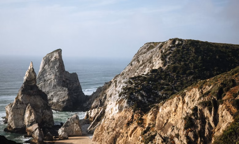 Golden sandy beach along Portugal’s Atlantic coast with dramatic scenic cliffs and rolling ocean waves, a picturesque family