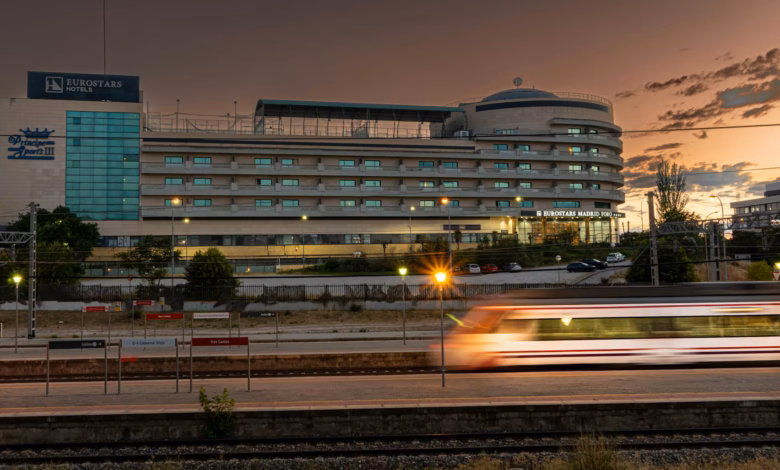Historic European train station with elegant architecture, nearby hotels, and a city street scene ideal for easy rail travel.