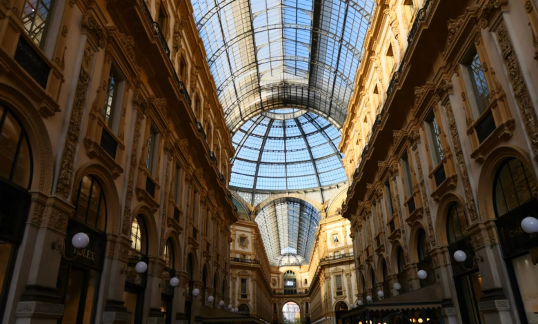 Elegant Milan shopping street lined with historic arcades, upscale storefronts, and classic Italian architecture in a stylish