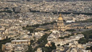 Historic Paris cityscape with the Eiffel Tower rising above the Seine River, elegant Haussmann buildings, and a clear skyline