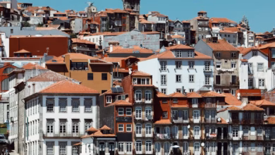 Colorful Ribeira waterfront and Dom Luís I Bridge spanning the Douro River in Porto, Portugal.