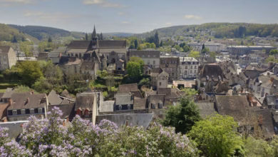 Charming stone village in the French countryside with narrow streets, rustic rooftops, and rolling green hills, capturing the