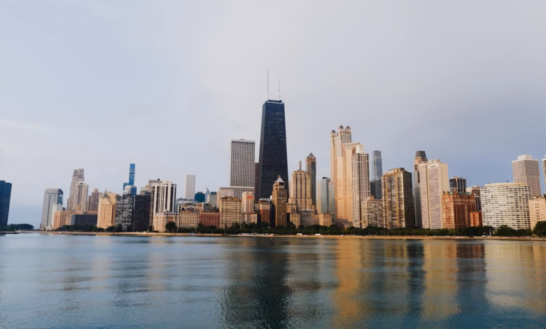 Chicago skyline with downtown skyscrapers, Lake Michigan shoreline, and green parkland along the waterfront under a clear cit