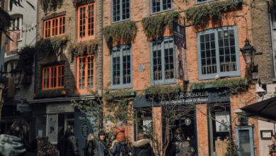 Historic Covent Garden market buildings with charming London cafe exteriors, glass storefronts, and cobblestone streets in a
