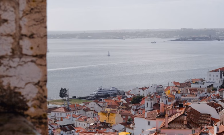 Lisbon city view with tiled buildings, scenic streets, and a coastal skyline over the hills of Portugal.