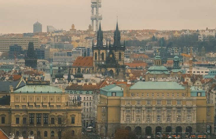 Prague Old Town skyline with medieval streets, historic Czech Republic architecture, and a distant castle view under a clear