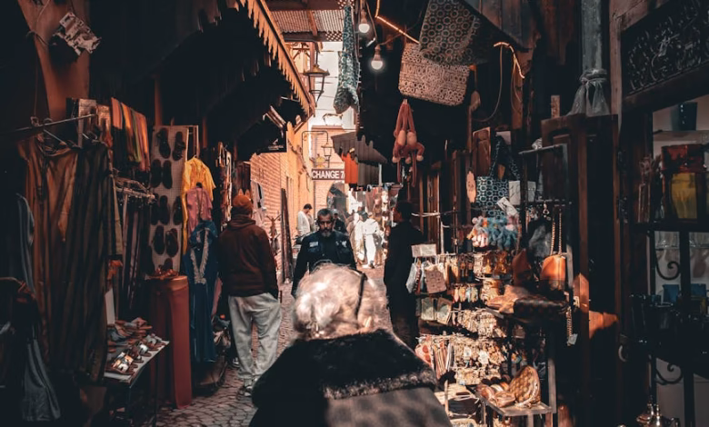 Colorful Marrakesh souk alley with traditional Moroccan architecture, hanging lanterns, and vibrant textiles in the market.