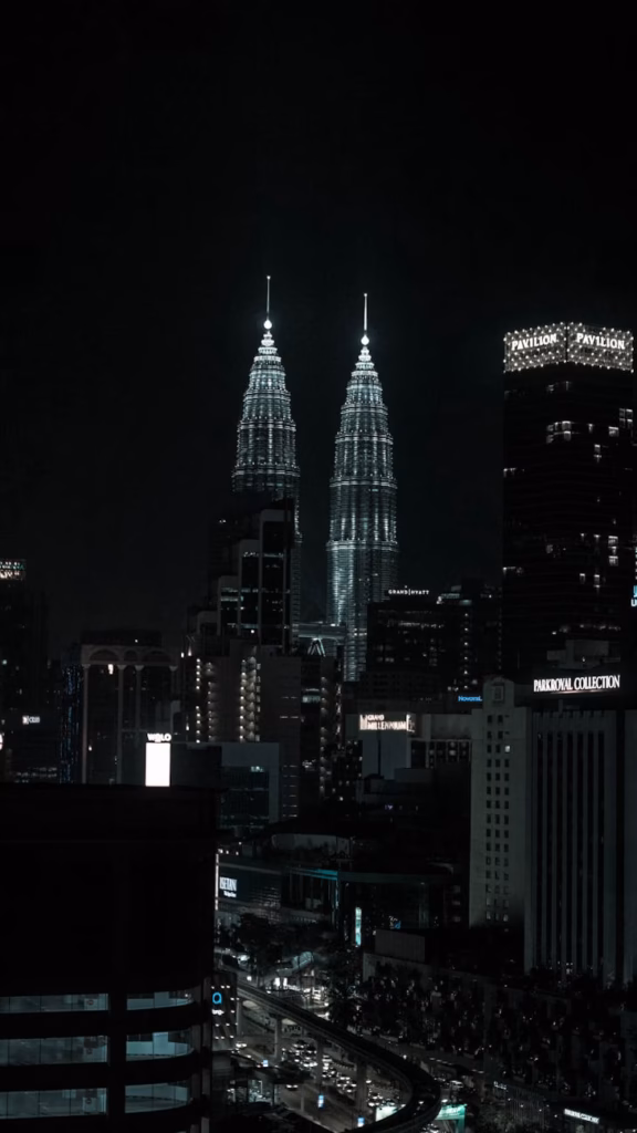 Kuala Lumpur skyline at night with the illuminated Petronas Towers, showcasing Malaysia’s modern cityscape and sleek urban ar