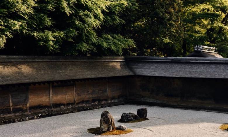 Quiet Kyoto Zen garden with raked white gravel, carefully placed rocks, and moss-covered temple landscaping, capturing tradit