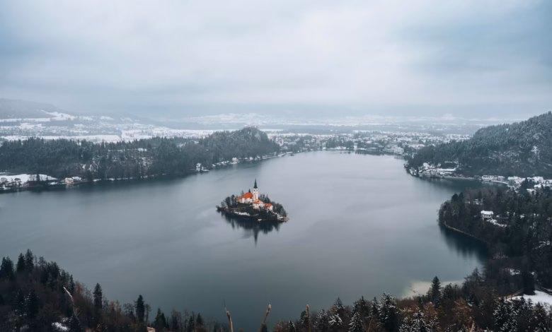 Emerald Lake Bled with its island church, medieval clifftop castle, and alpine mountain backdrop in Slovenia.