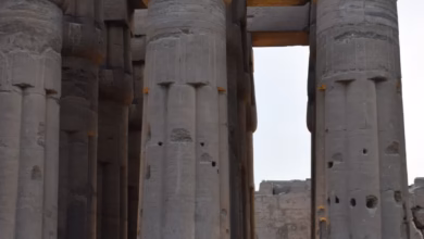 Ancient Luxor Egypt temples with towering stone columns, sunlit ruins, and a dramatic desert landscape along the Nile River.