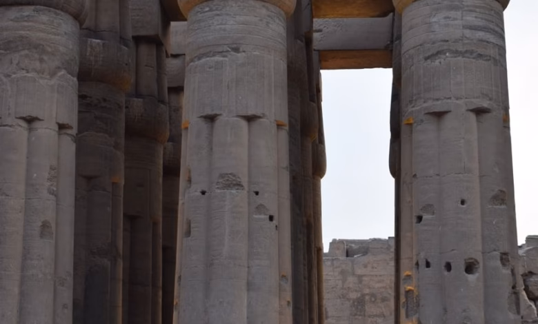Ancient Luxor Egypt temples with towering stone columns, sunlit ruins, and a dramatic desert landscape along the Nile River.