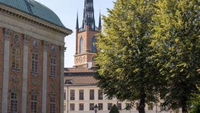 Stockholm garden path with lush greenery, historic palace architecture, and calm waterfront views in Sweden