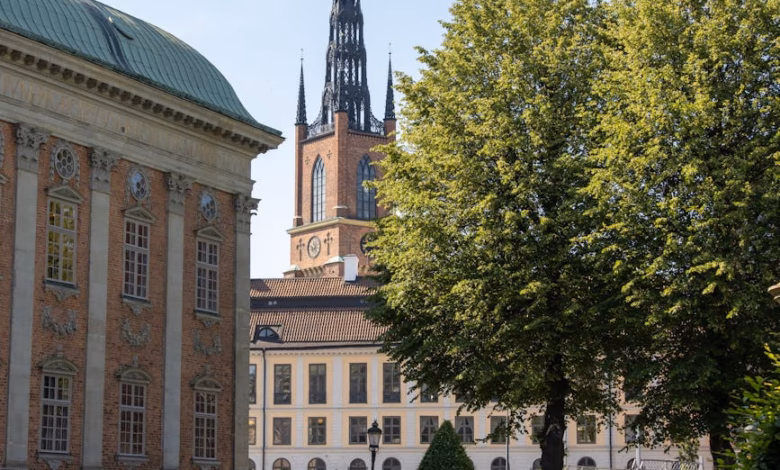 Stockholm garden path with lush greenery, historic palace architecture, and calm waterfront views in Sweden