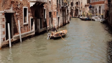 Venice canal view with historic buildings, a gondola on the water, and classic Italian architecture in a romantic cityscape