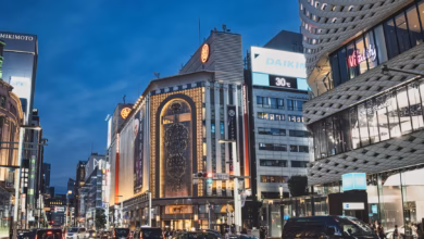 Illuminated Ginza Tokyo shopping district with luxury storefronts, modern city lights, and sleek urban architecture at night.