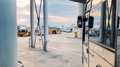 Modern airport shuttle hotel exterior with a convenient shuttle pickup area near the terminal, surrounded by clear road acces