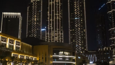 Modern luxury hotel exterior in Downtown Dubai with panoramic city skyline views, illuminated modern towers, and a vibrant ni