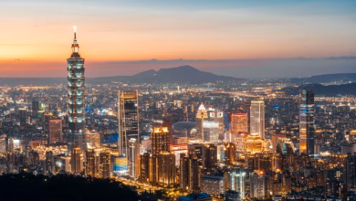 Taipei skyline at dusk with Taipei 101 rising above the city lights and surrounding urban mountains, capturing a scenic Taipe