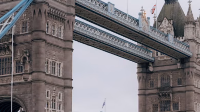 Tower Bridge in London spanning the Thames River, with historic Gothic-style towers and a scenic city skyline view.