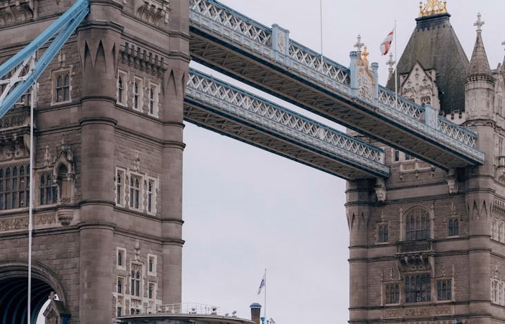 Tower Bridge London spanning the Thames River, a historic UK landmark with Victorian Gothic architecture and city skyline vie