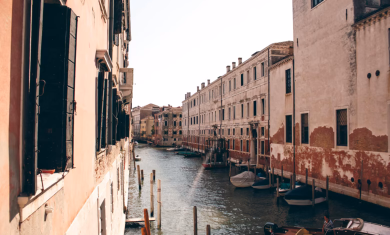 Venice canal view with historic buildings, arched bridges, and calm waterways beside a gondola in romantic Italy