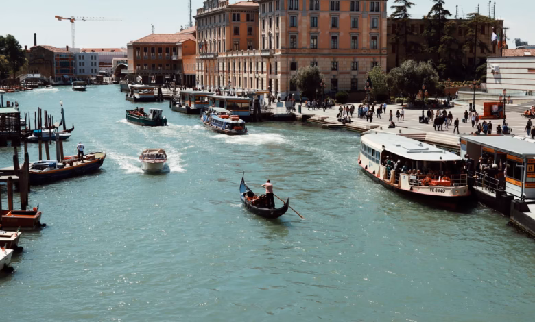 Venice’s iconic Grand Canal with historic Venetian palaces, arched bridges, and calm water under a bright Italian sky, showca