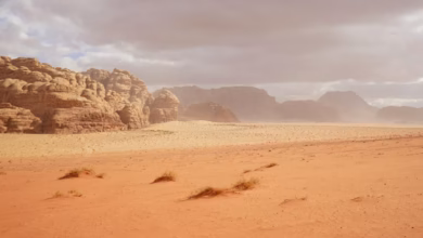 Wadi Rum desert landscape with towering Jordan sandstone mountains, red sand valley, and vast desert adventure scenery.