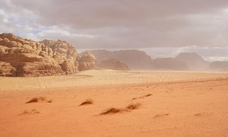 Wadi Rum desert landscape with towering Jordan sandstone mountains, red sand valley, and vast desert adventure scenery.