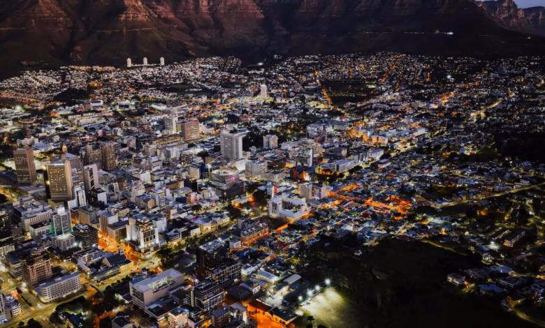 Cape Town cityscape with Table Mountain rising above the harbor and modern waterfront buildings, a scenic view for first-time